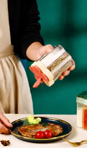 Vue détaillée versant des épices d'un pot à épices multi-compartiments sur le plat