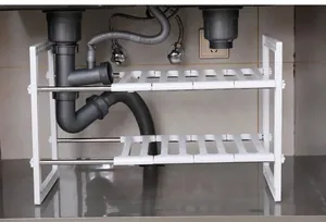 Two-tier expandable under-sink organizer rack showing installation around plumbing