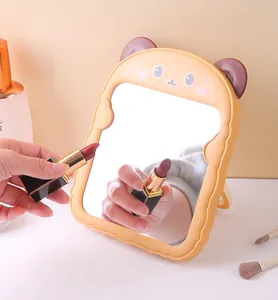Detailansicht eines niedlichen Katzenohr-Schminkspiegels mit Spiegelung eines Lippenstifts