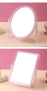 Detailed view of transparent rotating desktop makeup mirrors in oval and square shapes