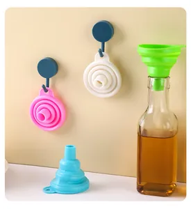 Embudos de silicona plegables de colores para cocina, mostrados colgados y en botella.