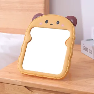Süßer Cartoon Toast Form Katzenohr Desktop Schminkspiegel auf einem Nachttisch aus Holz