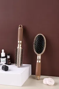 Detail eines luxuriösen goldenen Luftkissen-Haarmassagebürsten- und Rundkamm-Sets
