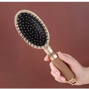 Close-up detail of a premium golden air cushion hairbrush handle with soft bristles.