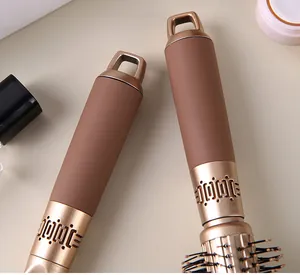 Detail view of ergonomic brown and gold hairbrush handles with hanging loops.