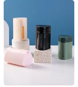 Set of elegant automatic press-type toothpick holders in pastel colors on textured props.