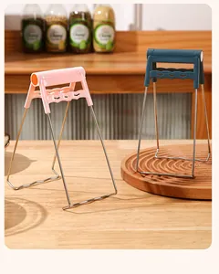 Detailed view of pink and blue anti-scald bowl grippers on a wooden kitchen table.