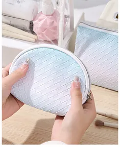 Close-up detail showing the blue gradient woven texture of the portable travel makeup pouch