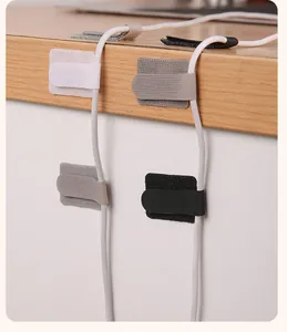 Détail des organisateurs de câbles Velcro adhésifs fixés sur le bord d'un bureau