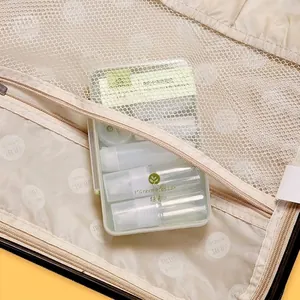 Portable travel toiletry bottle set in a beige mesh organizer bag for skincare use