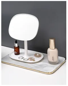 Minimalist white desktop makeup mirror with a 360-degree swivel stand and jewelry tray
