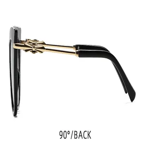 Vue de profil des lunettes de soleil œil-de-chat noires avec branches dorées ornées