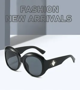 Detailed close-up of oversized black round sunglasses with crystal diamond temple accent