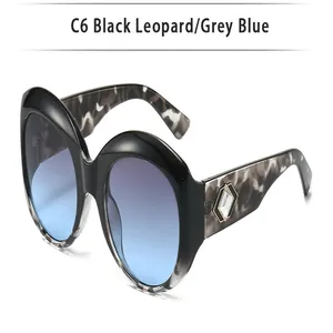 A detailed close-up view of oversized round sunglasses with blue leopard print