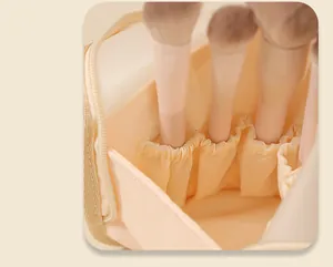 Close-up detail of the cream-colored makeup brush organizer bag interior with elastic slots