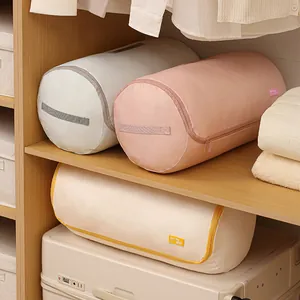 Large capacity cylindrical quilt storage bags in a tidy wooden wardrobe setting