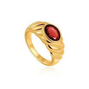Detailed close-up of a vintage 18K gold plated ribbed ring with an oval red zircon.