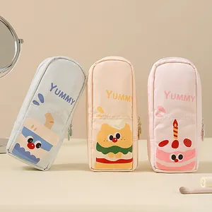 Set of three cute cartoon makeup brush storage pouches in pastel colors.