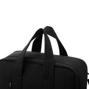 Black travel luggage storage bag with sturdy handles and TRAVEL tag detail