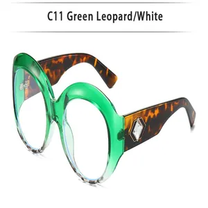 Stylish oversized round sunglasses with green frames and leopard print temples.