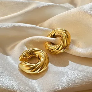Detail view of 18K gold plated stainless steel twisted ear bone clips on silk background.