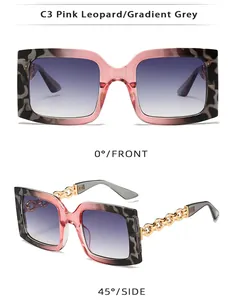 Détail de lunettes de soleil carrées oversize avec monture léopard rose et chaînes
