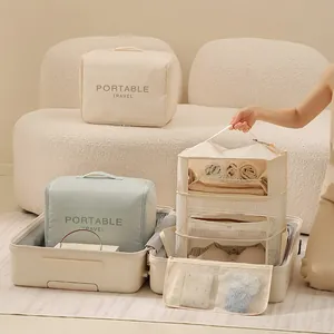 Portable hanging travel wardrobe organizer and storage bags in suitcase for clothes.