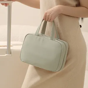 Sage green Taslon travel organizer bag with three-fold hanging design and dual handles