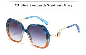Detail der modischen Damen Sonnenbrille mit blauem Leopard Farbverlauf und Perlendetail