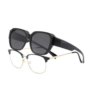 Occhiali da sole sovrapponibili neri con montatura ottica a giorno su sfondo bianco.