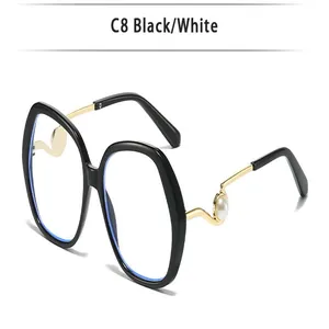 Detailaufnahme einer schwarzen Oversize-Brille mit goldfarbenen Perlen-Bügeln