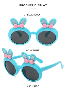 Detail view of blue children sunglasses featuring glittery bunny ears and pink bows.