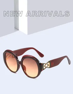 Detailed view of oversized burgundy round sunglasses with gradient lenses and gold accents.