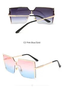 Détail de lunettes de soleil carrées oversize avec verres dégradés rose à bleu et bordure dorée