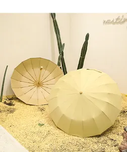 Vue détaillée de deux parapluies crème à 16 baleines dans un décor de désert