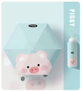 Macro detail view of a cute light blue pig pattern mini folding sun and rain umbrella