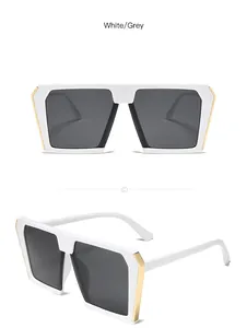 Detailansicht der übergroßen weißen quadratischen Sonnenbrille mit Goldakzenten.