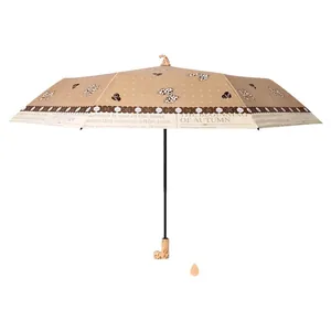 Paraguas beige plegable de tres secciones para sol y lluvia con diseño de lazos UV