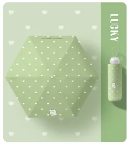 Top view of green 5-fold capsule umbrella with white heart pattern and folded case