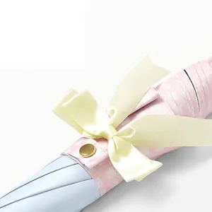 Close-up of automatic long-handle umbrella with elegant yellow ribbon bow