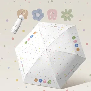 Mini portable white folding umbrella with colorful dots and cartoon motifs for sun and rain