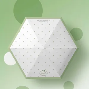 Green polka dot mini folding umbrella providing UV protection for sun and rain use