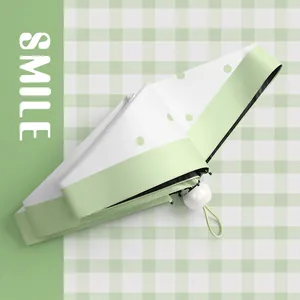 Compact light green polka dot capsule umbrella with UV protection for sun and rain