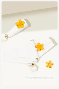 Close-up of compact white sunshade umbrella featuring yellow flower bud decor