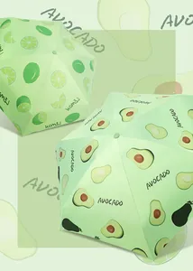Detailed view of fresh avocado and lemon fruit patterns on compact folding umbrellas.