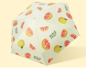 Close-up detail of a portable sun umbrella featuring a vibrant grapefruit slice pattern.
