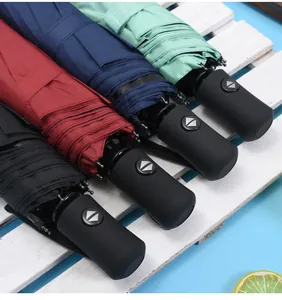 Detailed view of four colorful automatic folding umbrellas on a white wooden background