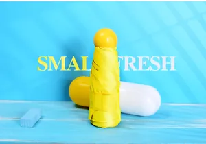 Detailed view of a compact yellow capsule sun umbrella with matching storage case