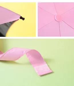 Detailed view of pink mini folding sun umbrella showing Velcro strap and top tip
