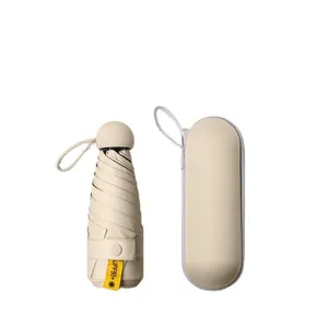 Compact beige capsule umbrella featuring UPF50+ sun protection and a matching hard case